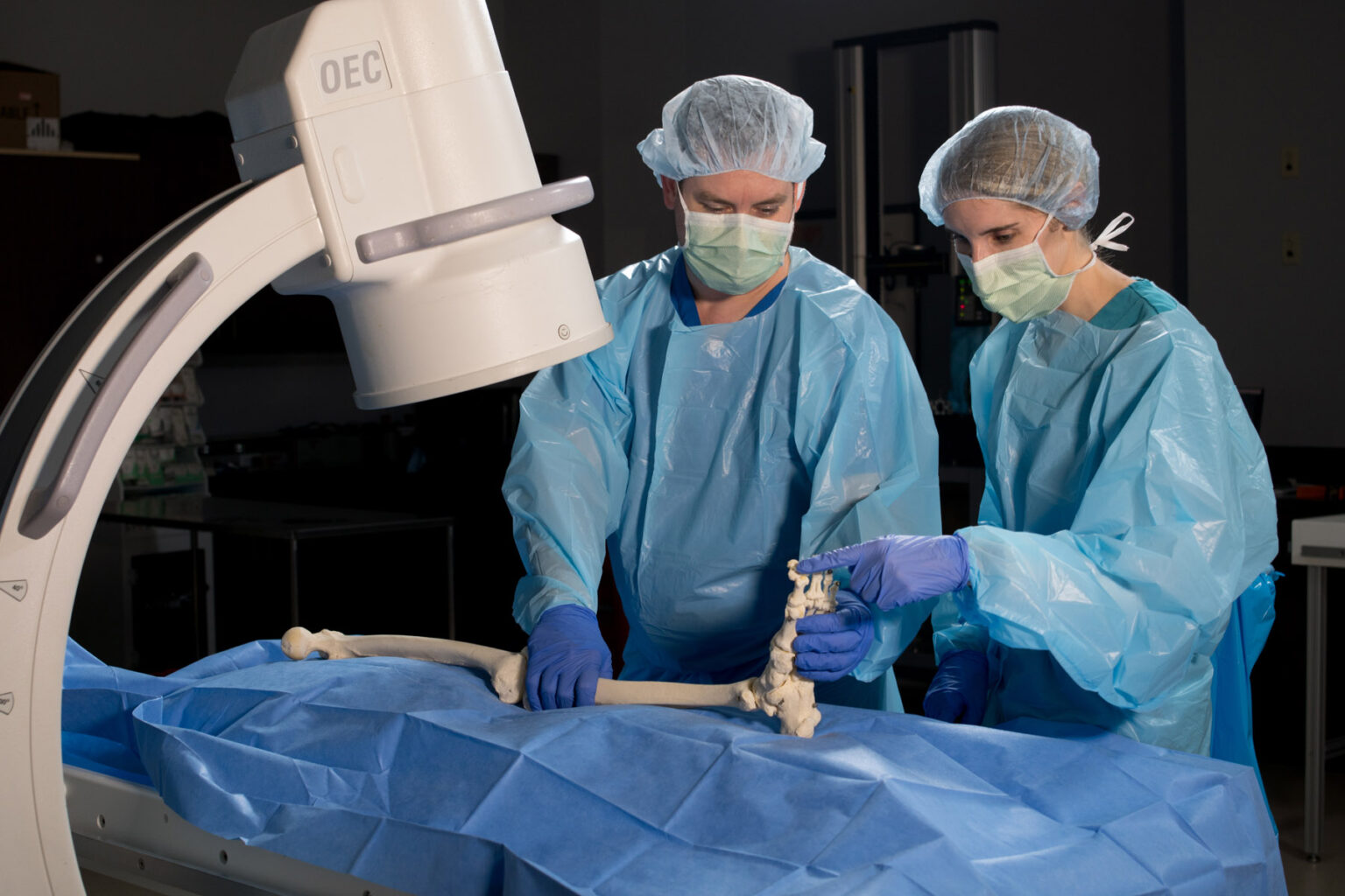Surgeons in an operating room analyzing the leg of a skeleton.