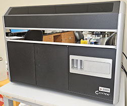 ISX machine on white lab bench. Reflection in front of machine shows a lab table with supplies on it.