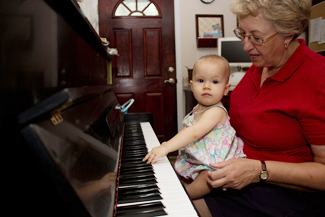 Lady with baby sits in front of piano