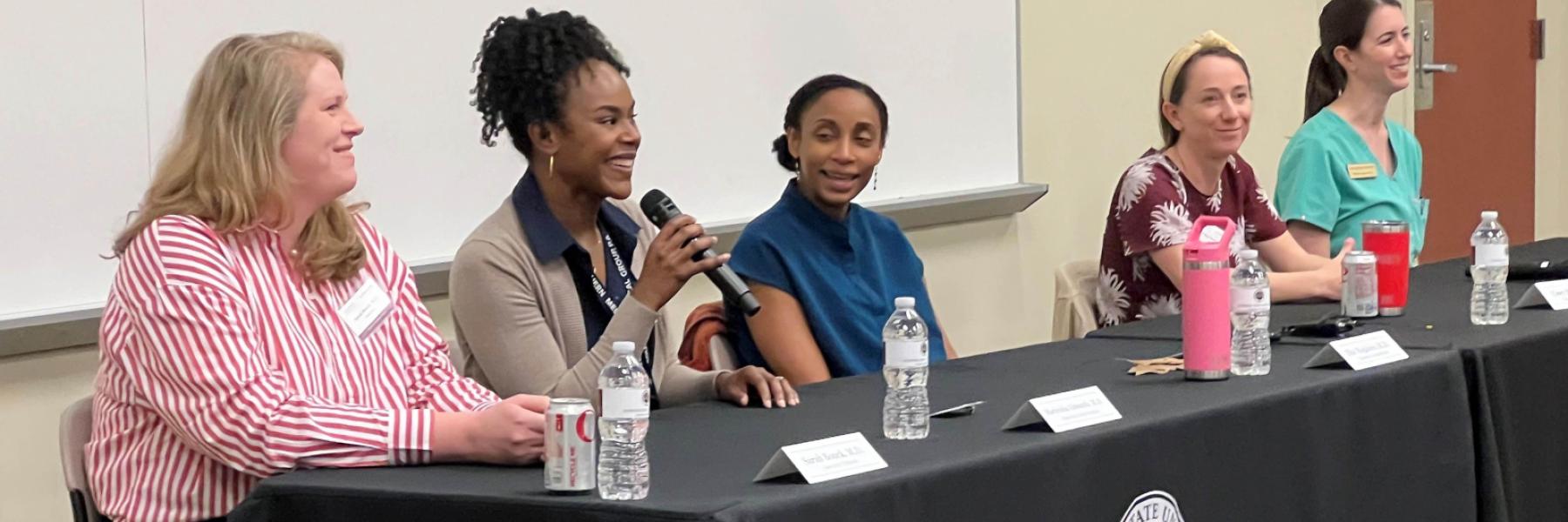 Dr. Marlisha Edwards, with microphone, and other panelists share their experiences and advice at the Women in Medicine panel discussion on March 13, 2024.