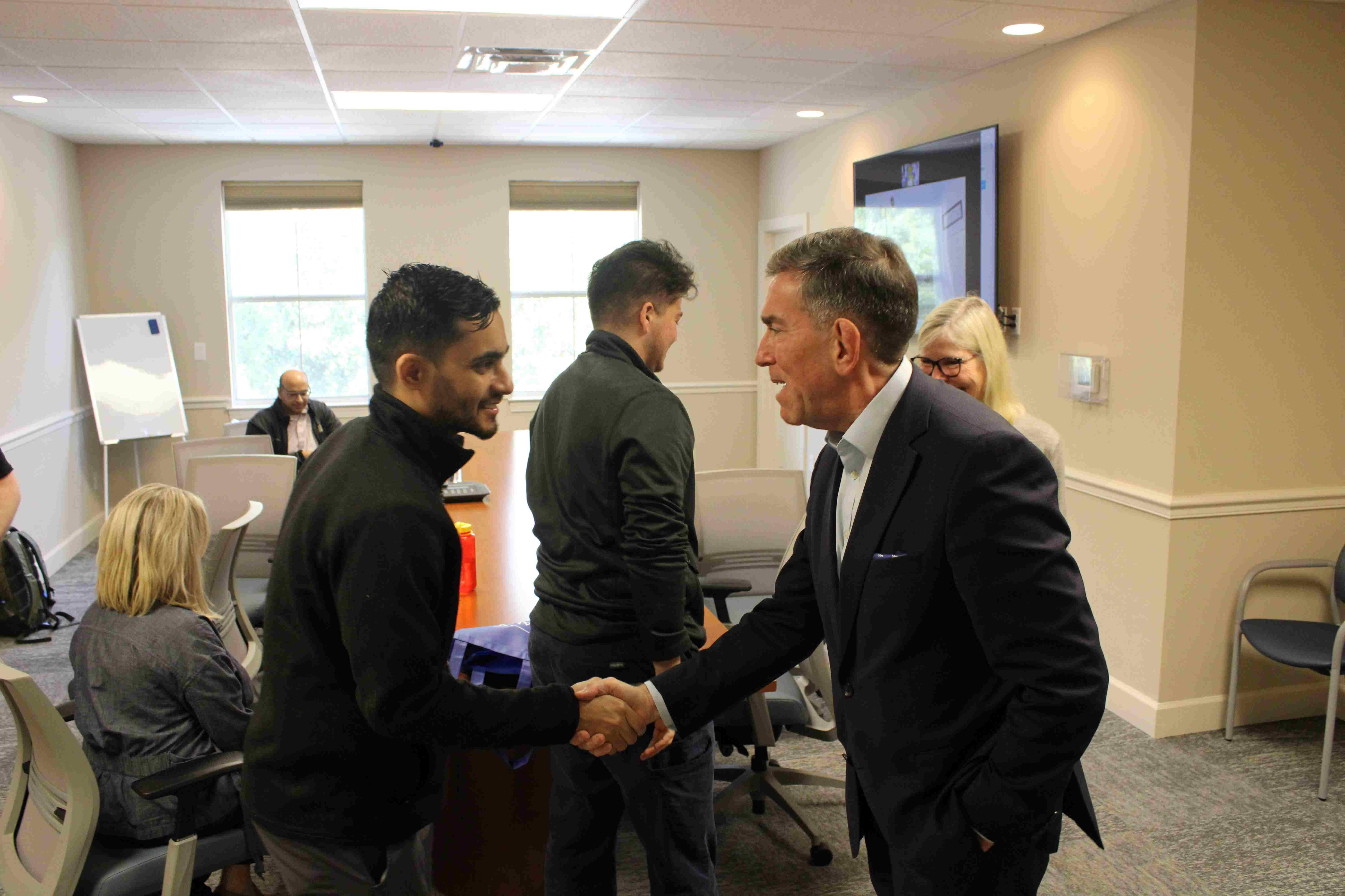Dr. Jay Reeve shaking hands with our Resident Rishi Kalia
