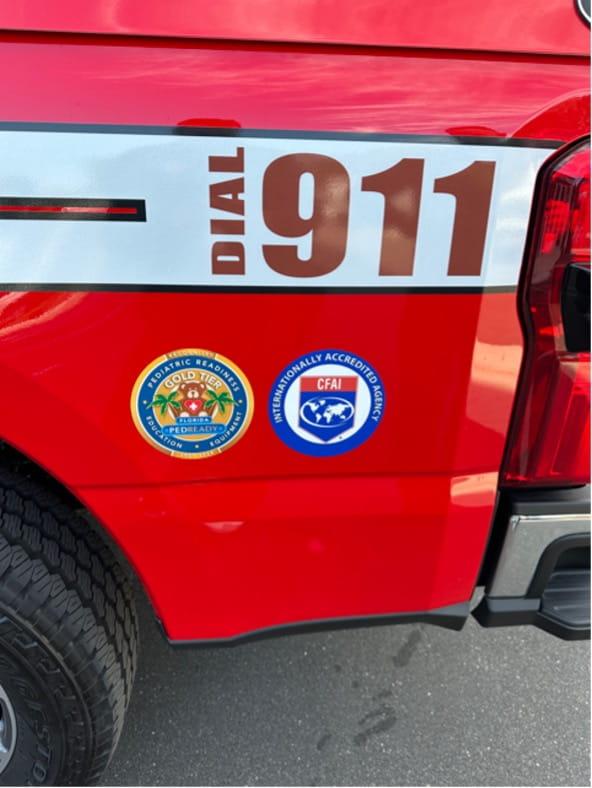 911 on the side of a fire truck with two stickers noting the local fire company