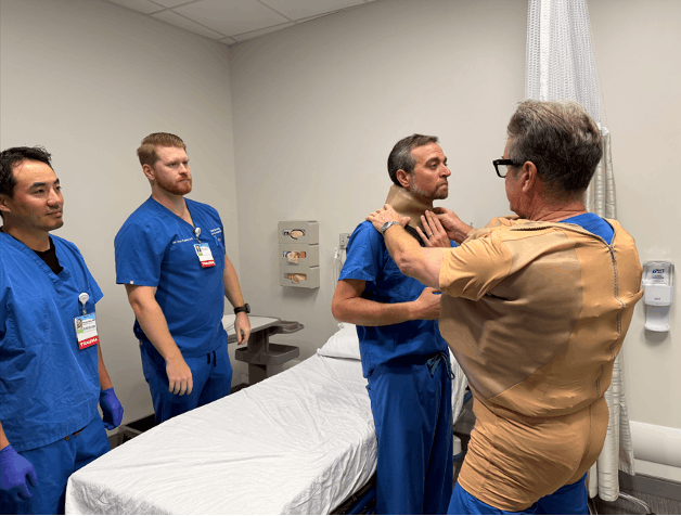 Fellows training in a hospital with one fellow wearing a brace on his neck