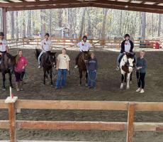 Students pose on horse back with Hands and Hearts for Horses staff.