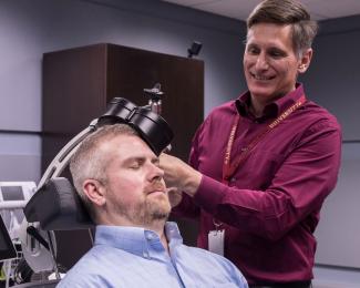 F. Andrew Kozel, M.D., demonstrates TMS technology with research associate Kevin Johnson, Ph.D.