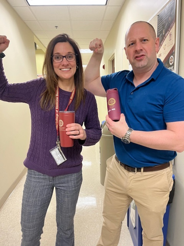 Robb Tomko and Toni Nemec holding cups and flexing