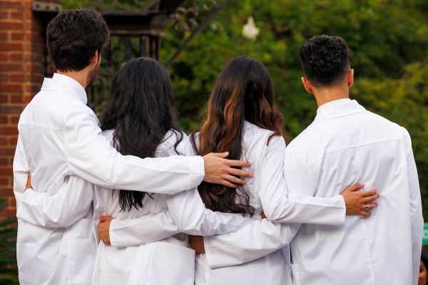 Students embracing after white coat ceremony