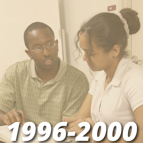 Timeline from 1996-2000, image shows a male and female student sitting at a table looking at a textbook together as if they are studying together for a test.