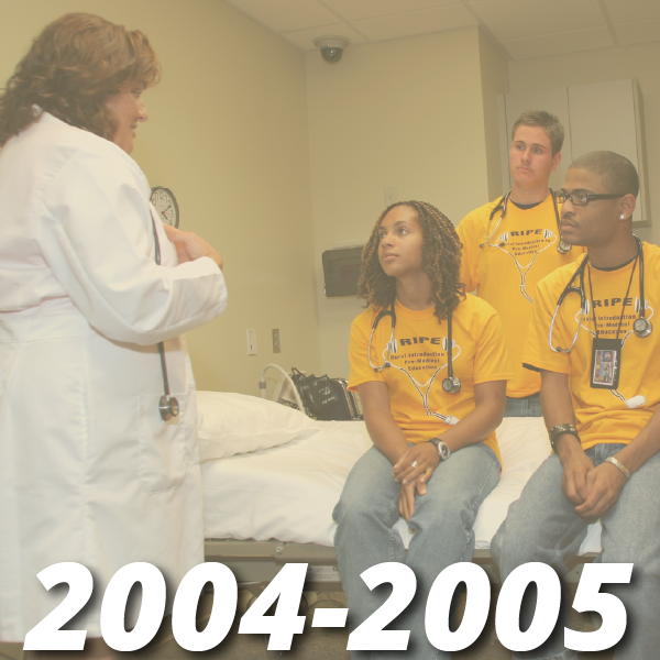 Timeline from 2004-2005, image shows three high school students in matching yellow t-shirts sitting inside a clinical learning center mock patient room with a female adult doctor in a white coat speaking to them as if she is teaching them something, the students and the doctor all have stethoscopes around their necks.
