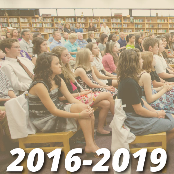 Timeline from 2016-2019, image shows what appears to be a library with rows of seats with high school students and parents sitting in seats listening to a speaker outside the view of the photo.