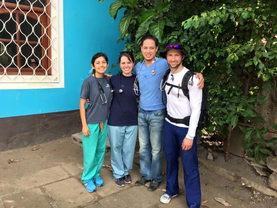 Four FSU faculty in front of a blue building