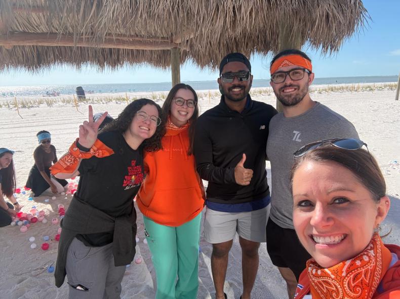 Five residents smiling at the beach