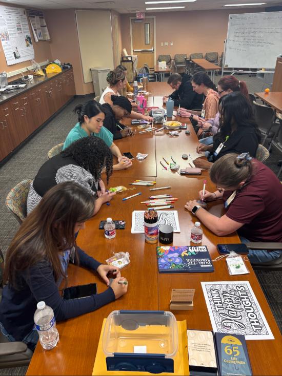 A group of residents sitting at a table working on art projects