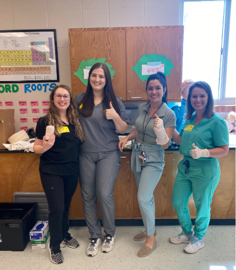 Four female residents give the thumbs up